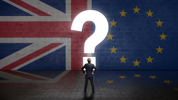 Portal in Form eines Fragezeichens in einer Wand mit UK- und EU-Flagge